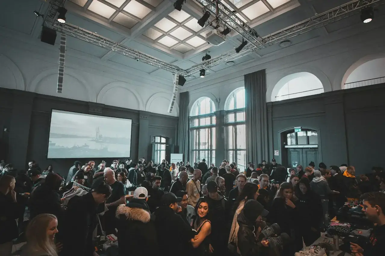 Gut besuchte Veranstaltung in einem Saal mit Bogenfenstern und Leinwand